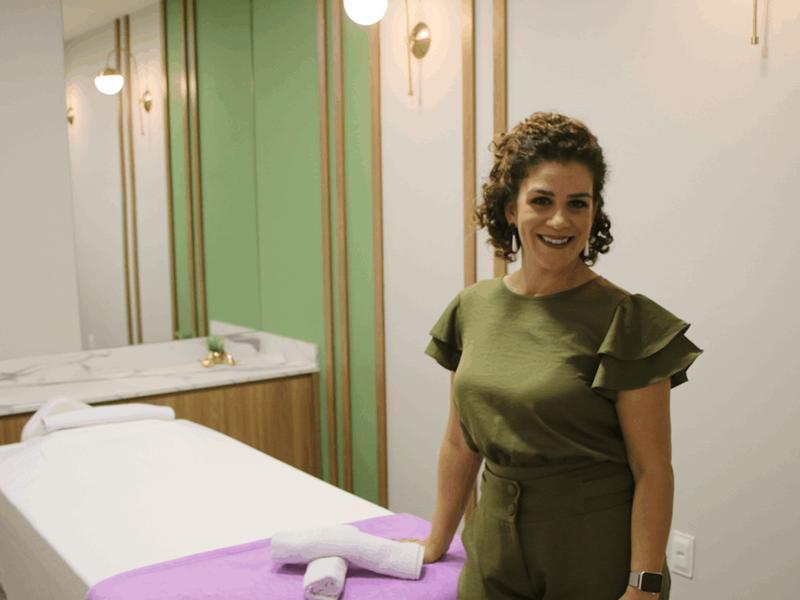 Luciana Langella na sala de atendimento, ao lado da maca